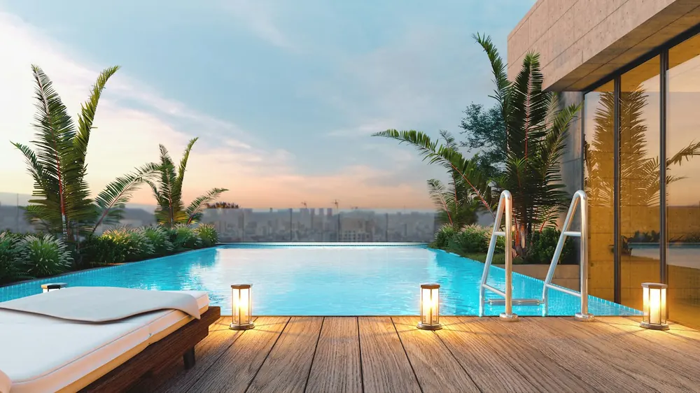 Rooftop infinity pool with a timber deck at dusk
